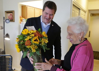 Larsen Jay delivers the nonprofit's 100,000th bouquet to Joan Taylor