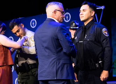 Jacob Bello having his new badge pinned on him by Andy McIlveen